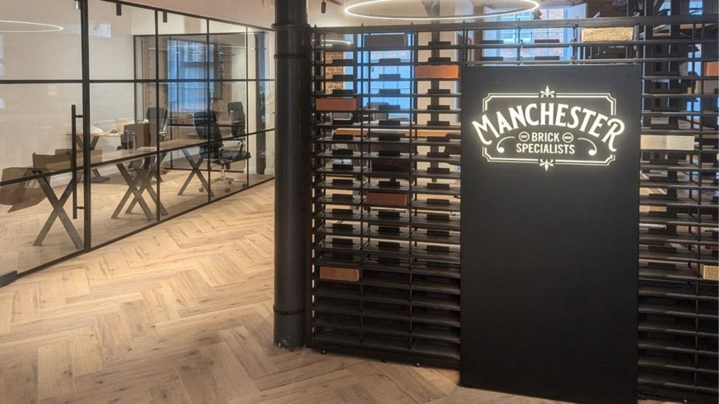 Entrance to Manchester Brick Specialists showroom featuring a modern industrial design, brick samples, and a prominently lit logo