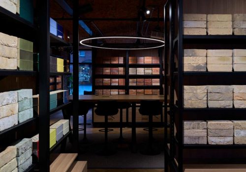 Entrance to Manchester Brick Specialists showroom featuring a modern industrial design, brick samples, and a prominently lit logo